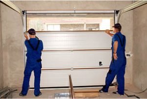 seksiyonel kapı montaj yapan mavi tulumlu personel